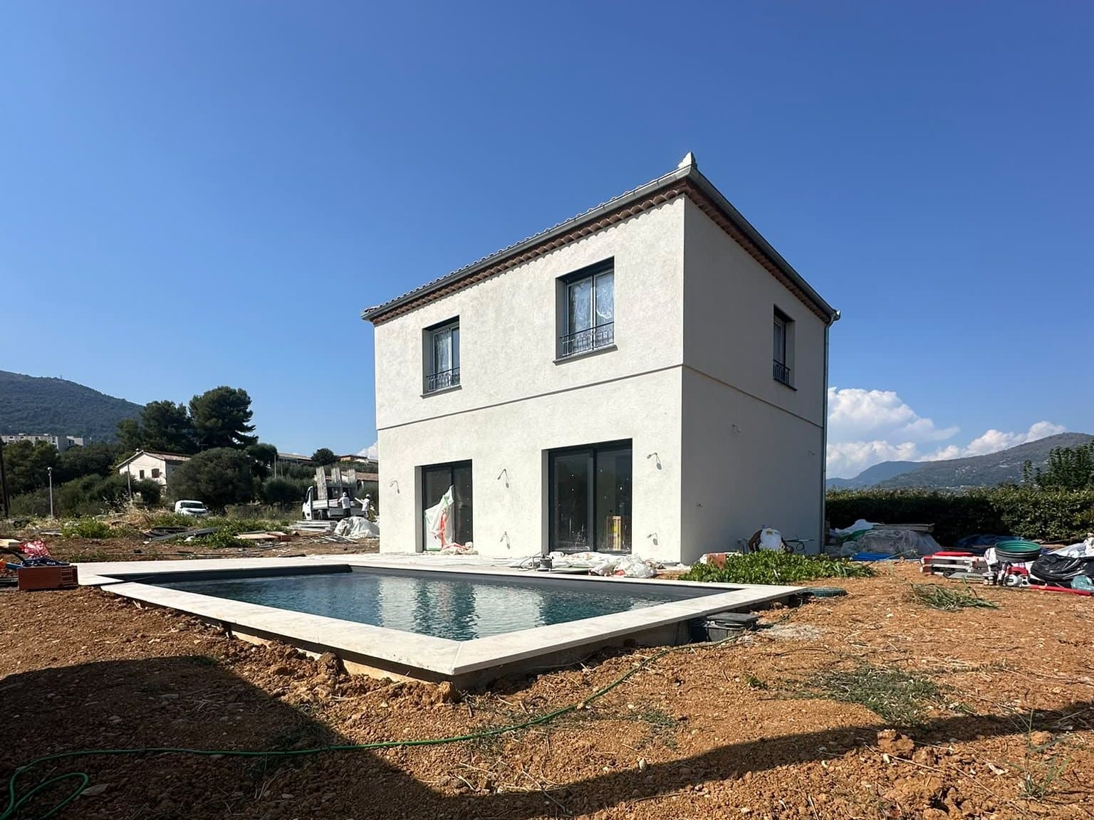 Maison neuve enduite et sa piscine, terrain en cours d'aménagement
