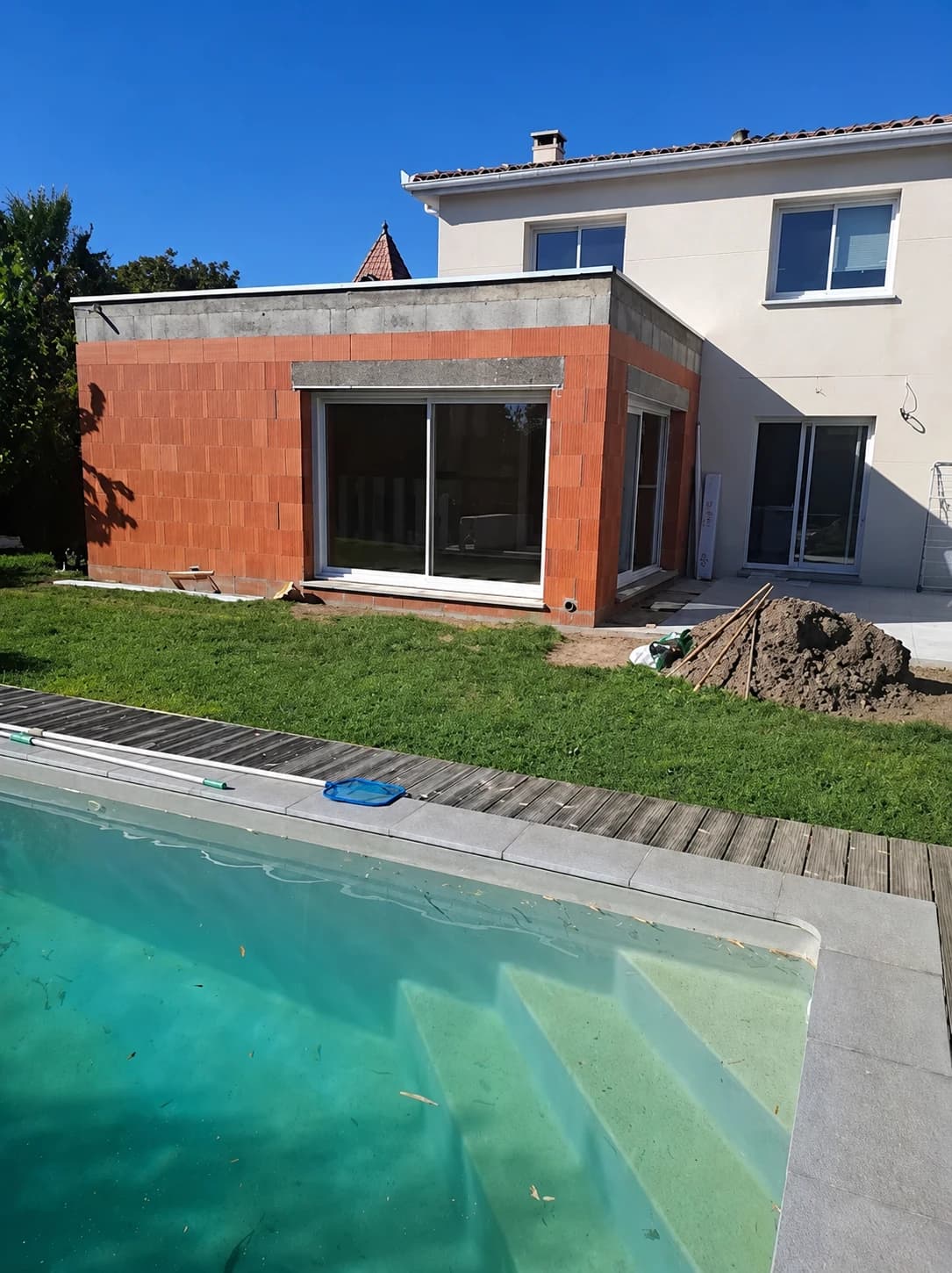 Extension en brique d'une maison avec piscine