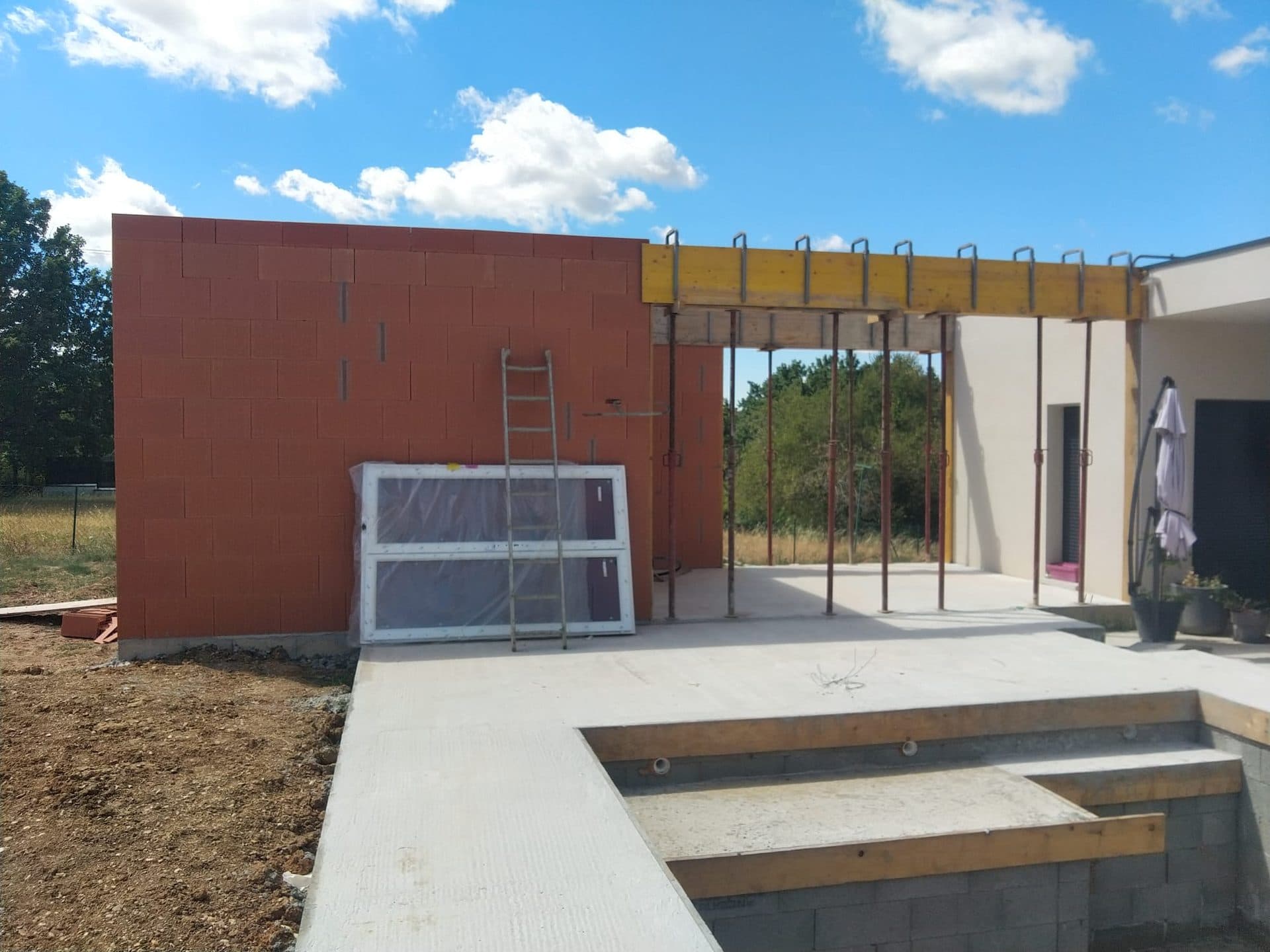 Extension enduite et ossature de pergola montée sur le toit-terrasse