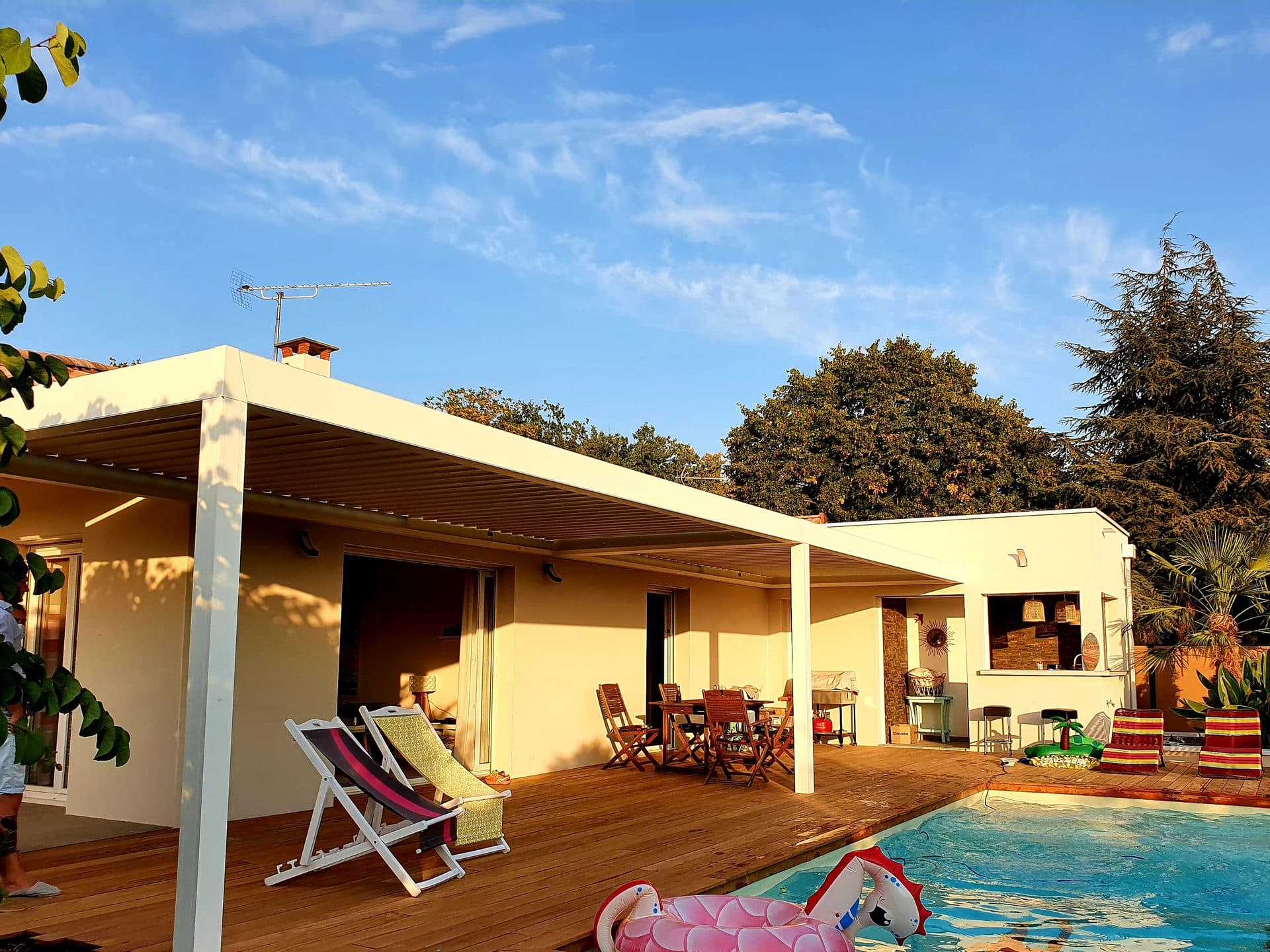 Terrasse couverte ouverte sur la piscine, avec espace de cuisine d'été