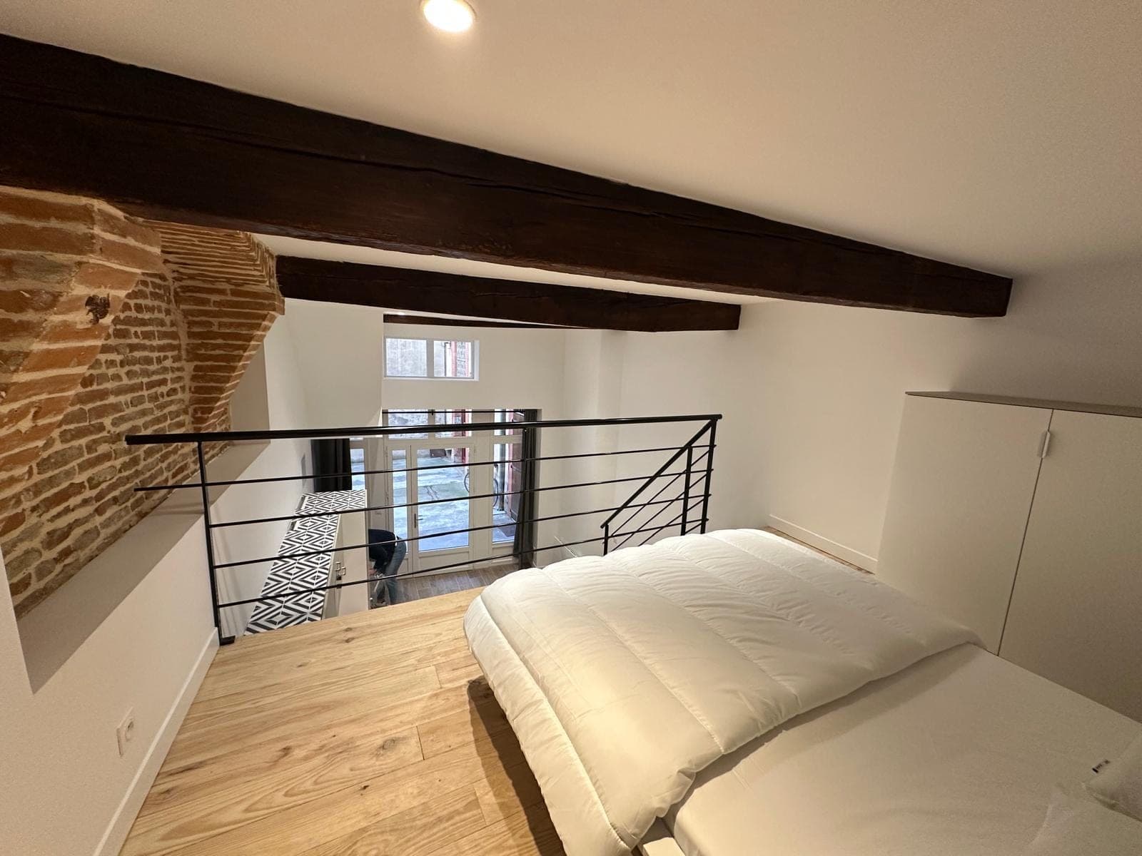 Loft toulousain avec mezzanine, murs de briques et poutres apparentes