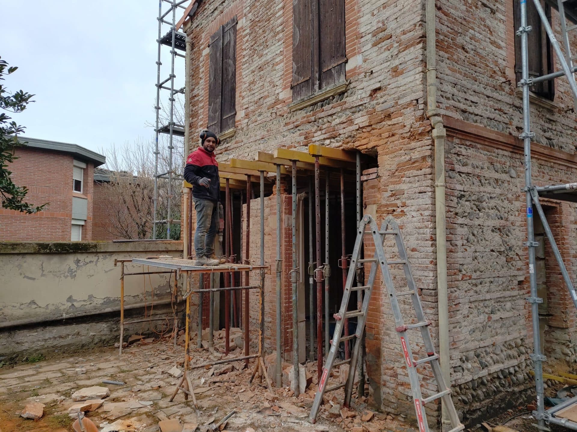 Reprise d'une façade en brique toulousaine sous échafaudage