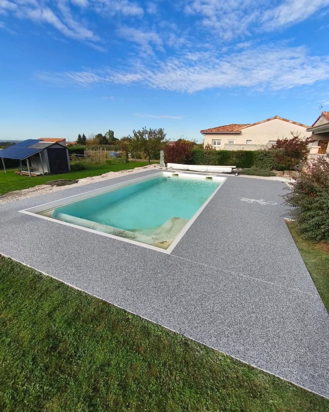 Bassin de piscine maçonné avec plage périphérique en moquette de pierre